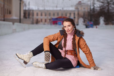 Ice skating woman sitting on the ice
