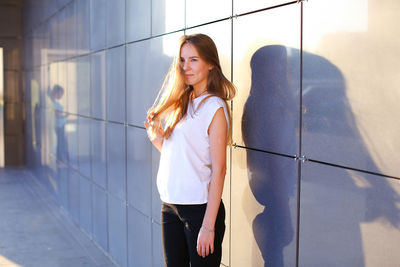 Portrait of young woman standing in city