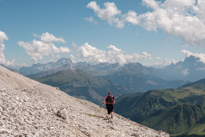 Rear view of man on mountain against sky