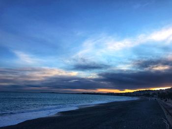 Scenic view of beach against sky at sunset