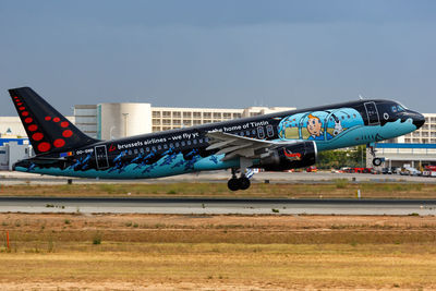 Airplane on airport runway against sky