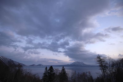 Scenic view of lake by trees against sky