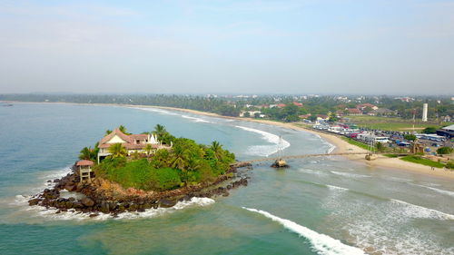 High angle view of buildings and sea against sky