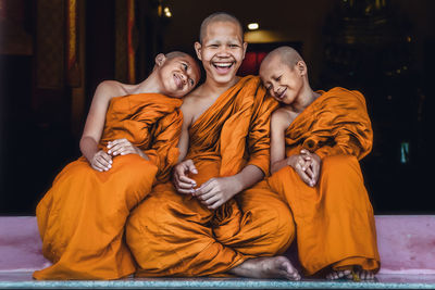 Smiling monks sitting outdoors