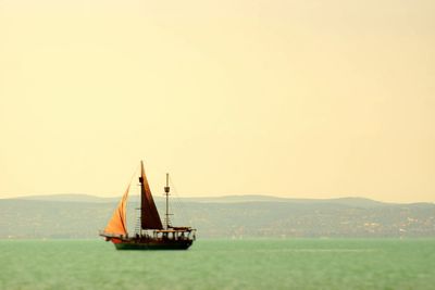 Sailboat sailing on sea against clear sky