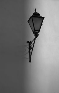 Low angle view of illuminated lamp hanging on wall