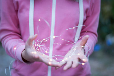 Close-up of woman holding pink flower