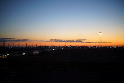 Illuminated city against sky during sunset