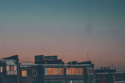 Buildings in city against clear sky during sunset