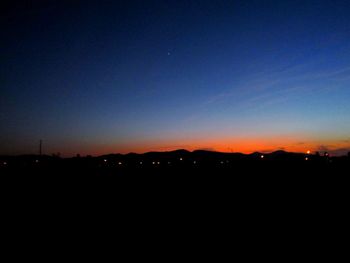 Silhouette buildings against sky at night