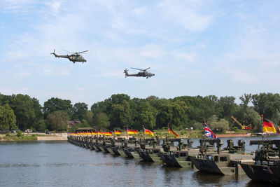 Helicopter flying over river against sky