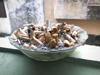 Close-up of burnt cigarettes in bowl