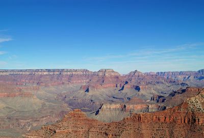 Rock formations on landscape against blue sky