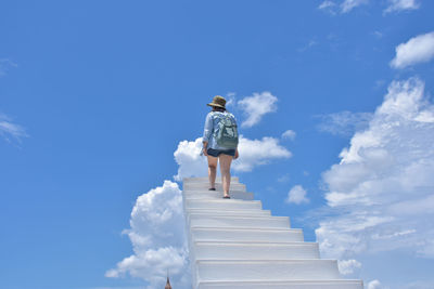 Rear view of woman standing against sky