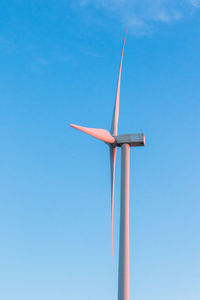 Low angle view of windmill against clear blue sky