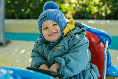 Portrait of cute boy sitting on slide