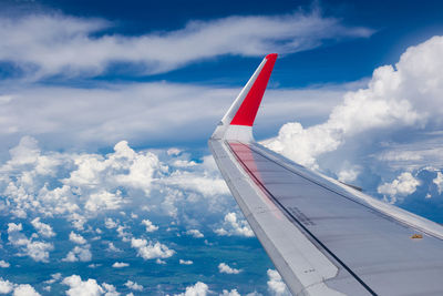 Airplane flying over clouds against blue sky