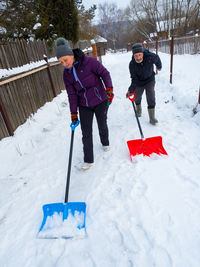 Senior man cleaning snow on street