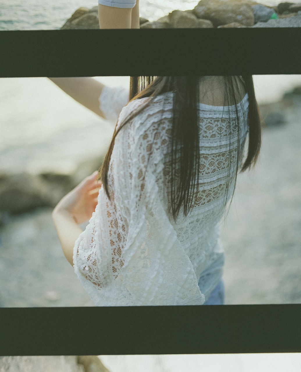 CLOSE-UP OF WOMAN STANDING ON RAILING