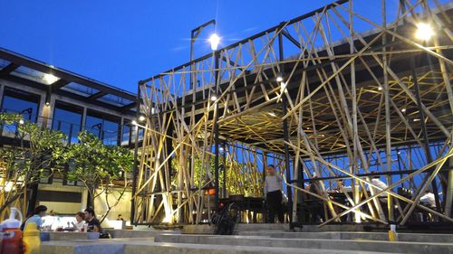 Low angle view of illuminated bridge against blue sky