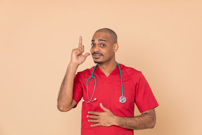 Portrait of young man standing against gray background