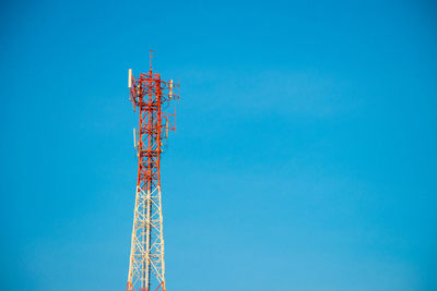 Low angle view of communications tower against blue sky