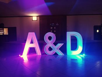 Low angle view of illuminated text on wall at night