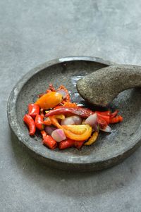 High angle view of chili sambal ingredients on stone mortar 