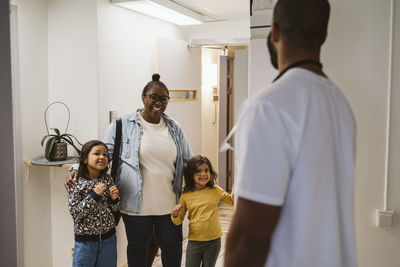 Happy mother with daughters visiting medical clinic