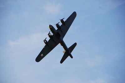 Low angle view of airplane flying against sky