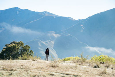 Rear view of man on mountain against sky