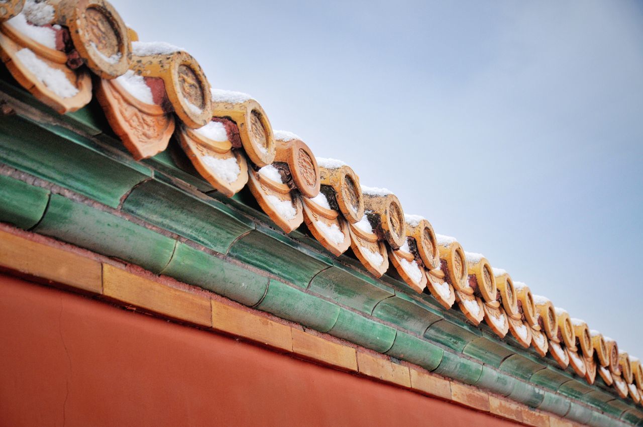 low angle view, no people, pattern, sky, day, built structure, roof, architecture, nature, copy space, in a row, outdoors, building exterior, close-up, wood - material, clear sky, wall - building feature, green color, order, brown, roof tile