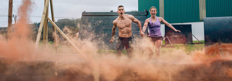 Sports friends holding hands while running on land