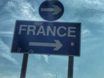 Low angle view of road sign against sky