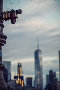 Statue in city against cloudy sky