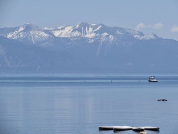 Scenic view of sea and snowcapped mountains against sky