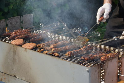 Cropped image of man cooking on barbecue in yard