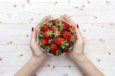 High angle view of hand holding fruits on table