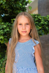 Portrait face of candid happy little kid girl of eight years old with long blond hair and green eyes