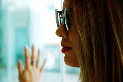 Close-up side view of young woman wearing sunglasses