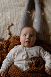 Portrait of cute baby girl lying on bed at home