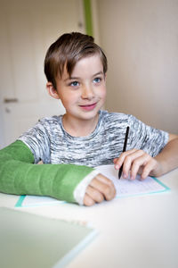 Portrait of boy with book on table