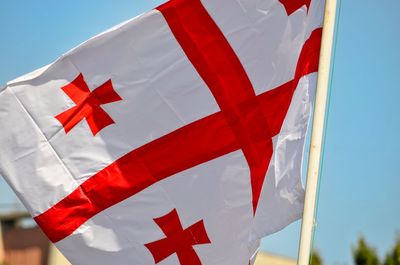 Low angle view of flag against blue sky