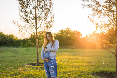 Portrait of woman on field against sky during sunset