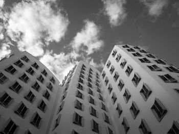 Low angle view of skyscraper against cloudy sky