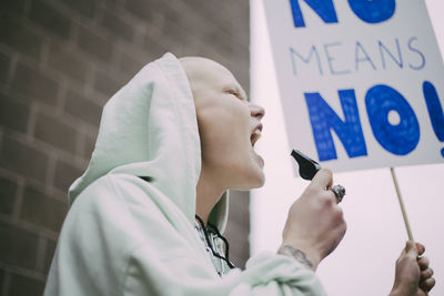 Female activist screaming with signboard during social movement