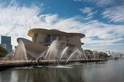 Scenic view of river by buildings against sky