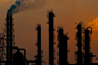 Silhouettes of factory chimneys and distillation towers
