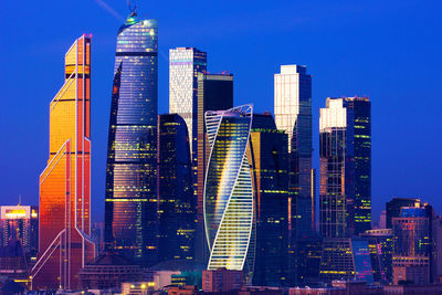 Aerial view of illuminated buildings in city against sky