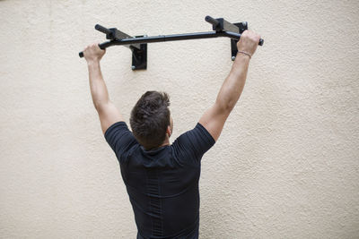 Rear view of man standing against wall